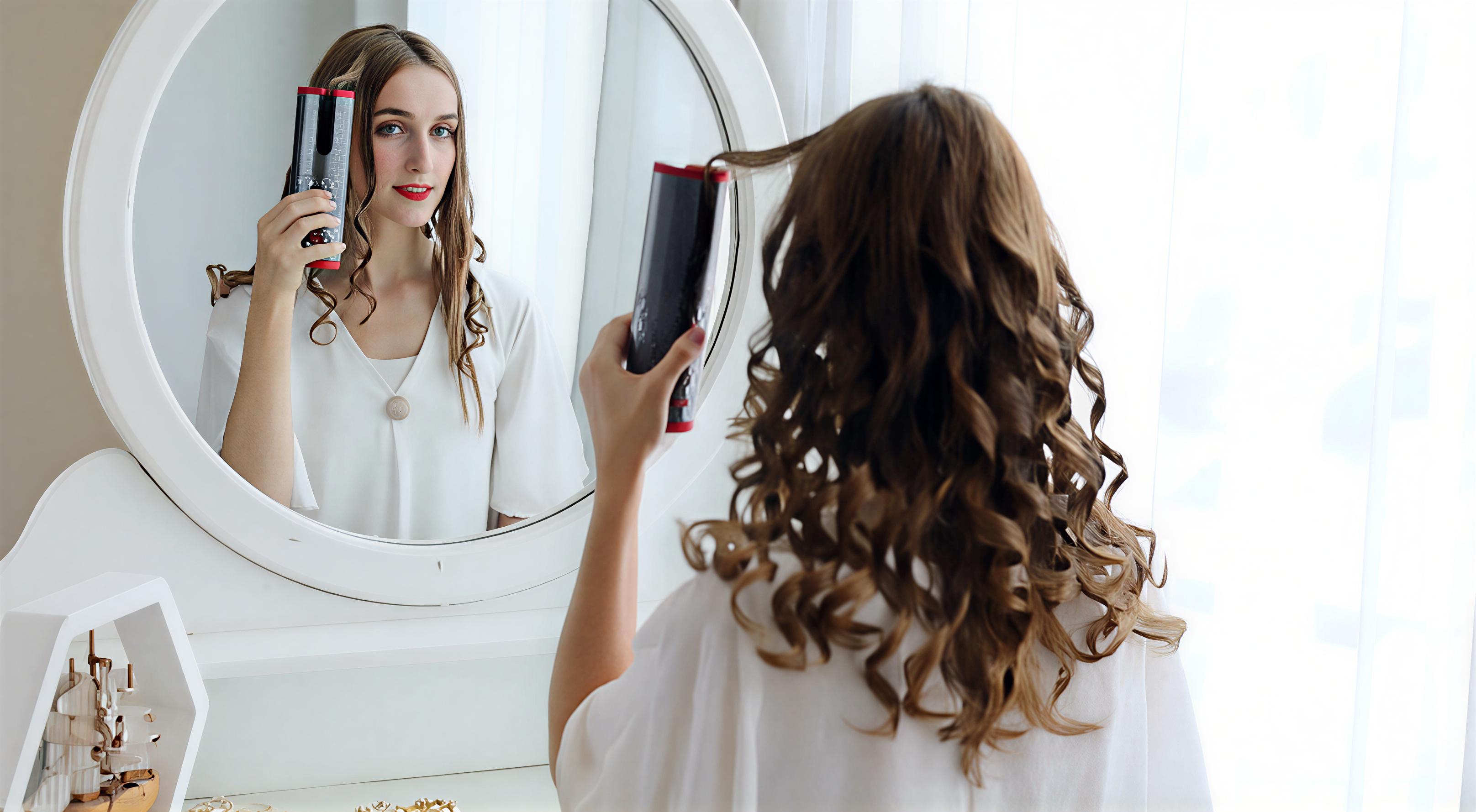 Kvinne som bruker LuxeCurl™ trådløs automatisk krølltang for å lage krøller hjemme